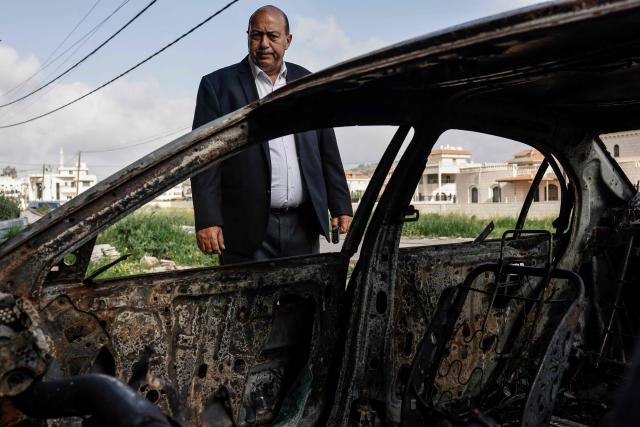 A Palestinian man inspects a burnt car following a reported attack by Israeli settlers in Turmus Ayya village, north of Ramallah in the Israeli-occupied West Bank on April 19, 2026. Violence in the West Bank, which Israel has occupied since 1967, has risen sharply since the October 7, 2023 Hamas attack on Israel triggered the Gaza war. There has also been a spike in deadly attacks by Israeli settlers in the West Bank since the start of the Iran war on February 28, Palestinian authorities and the United Nations have said. (Photo by Zain JAAFAR / AFP)