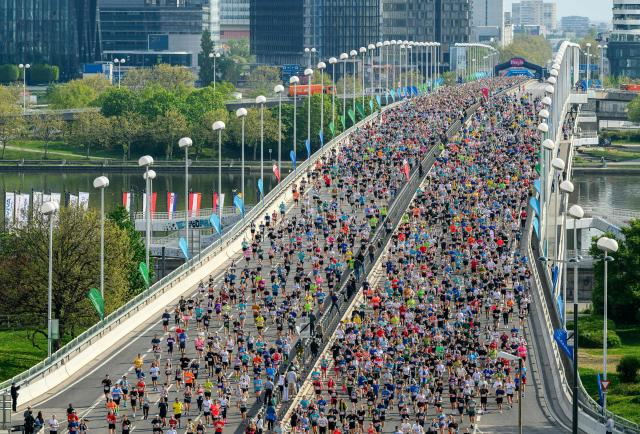 Runners take part in the Vienna City Marathon, crossing the Danube River via the Reichsbrücke bridge in Vienna on April 19, 2026. (Photo by MAX SLOVENCIK / APA / AFP) / Austria OUT