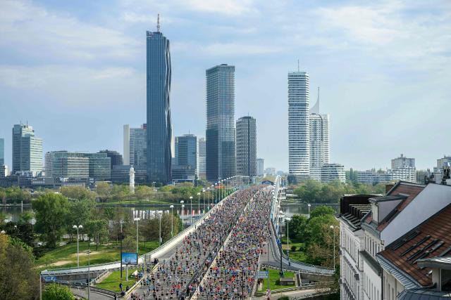 Runners cross the Danube River via the Reichsbrücke bridge during the Vienna City Marathon in Vienna on April 19, 2026. (Photo by MAX SLOVENCIK / APA / AFP) / Austria OUT