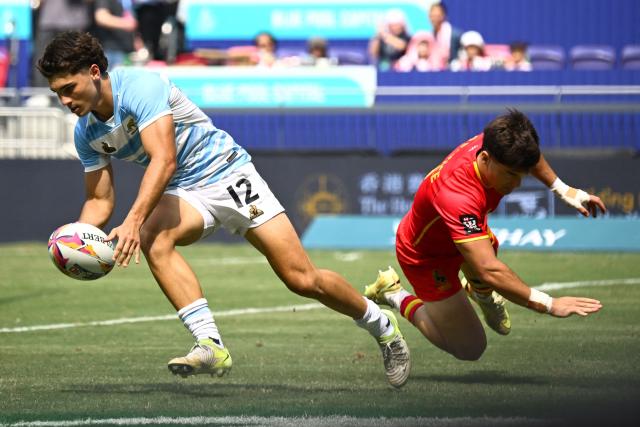 Argentina's Sebastian Dubuc (L) scores a try during the Cup semifinals match between Argentina and Spain on the third day of the 2026 Rugby Sevens Hong Kong tournament at Kai Tak Stadium in Hong Kong on April 19, 2026. (Photo by Peter PARKS / AFP)
