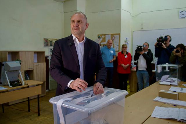 Progressive Bulgaria coalition's leader and former President Rumen Radev (C) casts his ballot at a polling station during Bulgaria's parliamentary elections in Sofia on April 19, 2026. Bulgarians vote in the country's eighth election in five years today, with ex-president Rumen Radev's grouping tipped to win on a pledge to fight corruption, after an anti-graft movement triggered a long political crisis. (Photo by Dimitar KYOSEMARLIEV and Dimitar KYOSEMARLIEV / AFP)