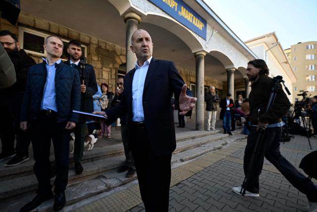 Progressive Bulgaria coalition's leader and former President Radev Rumen (C) addresses media after casting  at a polling station during Bulgaria's parliamentary elections in Sofia on April 19, 2026. Bulgarians vote in the country's eighth election in five years today, with ex-president Rumen Radev's grouping tipped to win on a pledge to fight corruption, after an anti-graft movement triggered a long political crisis. (Photo by Dimitar KYOSEMARLIEV and Dimitar KYOSEMARLIEV / AFP)