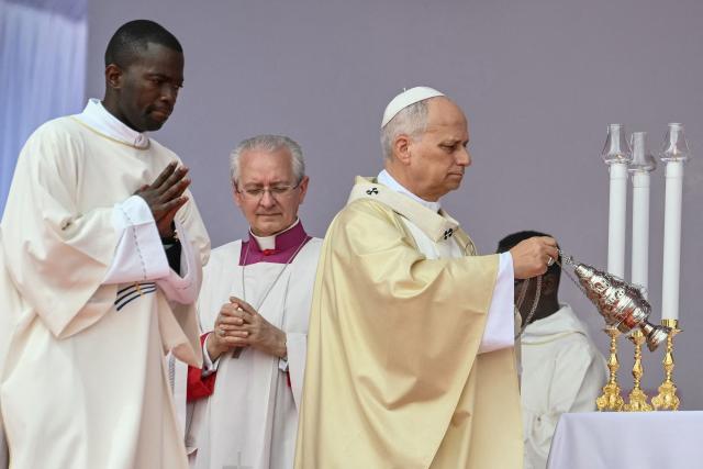 Pope Leo XIV (R) swings the thurible as he leads a Holy Mass in Kalimba on the seventh day of an 11-day apostolic journey to Africa, on April 19, 2026. (Photo by Alberto PIZZOLI / AFP)