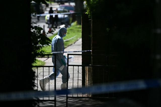 Police forensic officers work inside a cordon set up near to Kenton United Synagogue in Harrow, north-west London on April 19, 2026, the scene of an arson attack overnight. (Photo by JUSTIN TALLIS / AFP)