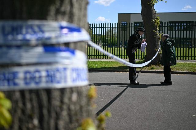 A member of the public speaks with a police officer at a cordon set up near to Kenton United Synagogue in Harrow, north-west London on April 19, 2026, the scene of an arson attack overnight. (Photo by JUSTIN TALLIS / AFP)