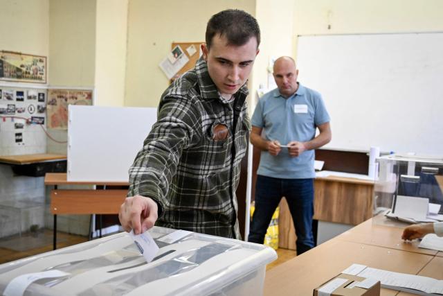 A voter casts his ballot at the polling station during Bulgaria's parliamentary elections in Sofia on April 19, 2026. Bulgarians vote in the country's eighth election in five years today, with ex-president Rumen Radev's grouping tipped to win on a pledge to fight corruption, after an anti-graft movement triggered a long political crisis. (Photo by Dimitar KYOSEMARLIEV / AFP)