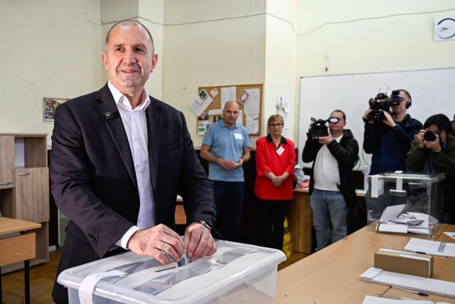 Progressive Bulgaria coalition's leader and former President Rumen Radev (C) casts his ballot at a polling station during Bulgaria's parliamentary elections in Sofia on April 19, 2026. Bulgarians vote in the country's eighth election in five years today, with ex-president Rumen Radev's grouping tipped to win on a pledge to fight corruption, after an anti-graft movement triggered a long political crisis. (Photo by Dimitar KYOSEMARLIEV / AFP)