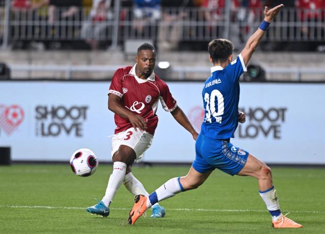OGFC's Patrice Evra (L) fights for the ball with Suwon Samsung Legends' Shin Se-gye (R) during a friendly football match between OGFC, a newly formed football club by Premier League legends from Manchester United, and South Korea's Suwon Samsung Legends in Suwon on April 19, 2026. (Photo by Jung Yeon-je / AFP)