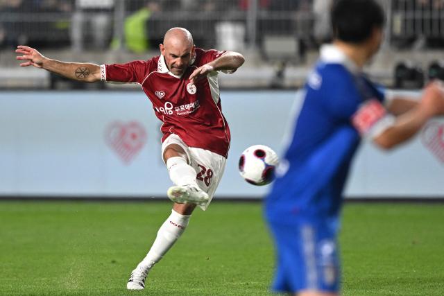 OGFC's Darron Gibson (L) takes a free kick during a friendly football match between OGFC, a newly formed football club by Premier League legends from Manchester United, and South Korea's Suwon Samsung Legends in Suwon on April 19, 2026. (Photo by Jung Yeon-je / AFP)