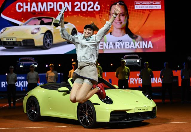 The winner Kazakhstan’s Elena Rybakina jumps with the trophy in front of the winner’s car after defeating Czech Republic’s Karolina Muchova (not in picture) in the final match at the Women's Tennis Grand Prix WTA tournament in Stuttgart, southwestern Germany, on April 19, 2026. (Photo by THOMAS KIENZLE / AFP)