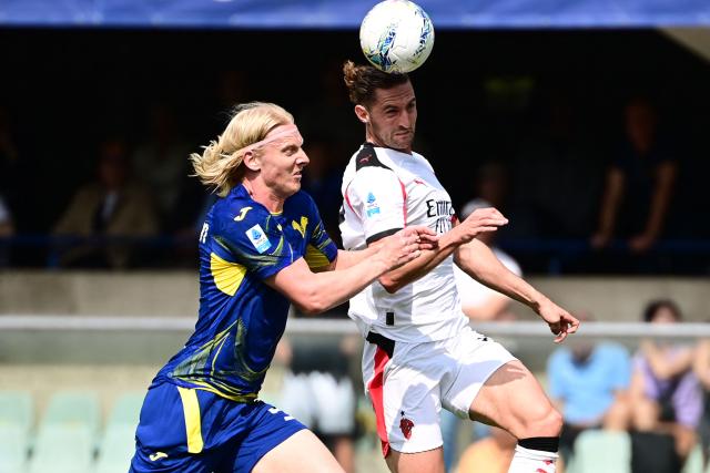 Hellas Verona's defender #05 Andrias Edmundsson (L) fights for the ball with AC Milan's French midfielder  #12 Adrien Rabiot during the Italian Serie A football match between Hellas Verona and AC Milan at the  Marcantonio Bentegodi stadium in Verona, on April 19, 2026. (Photo by PIERO CRUCIATTI / AFP)