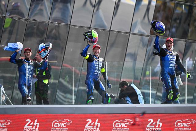 (From L) Yart Yamaha Official team's Argentine formula EWC rider Leandro Mercado, Yart Yamaha Official team's German formula EWC rider Marvin Fritz and Yart Yamaha Official team's Czech formula EWC rider Karel Hanika celebrate after winning the 49th Le Mans 24-hours endurance moto race, in Le Mans, northwestern France, on April 19, 2026. (Photo by JULIEN DE ROSA / AFP)