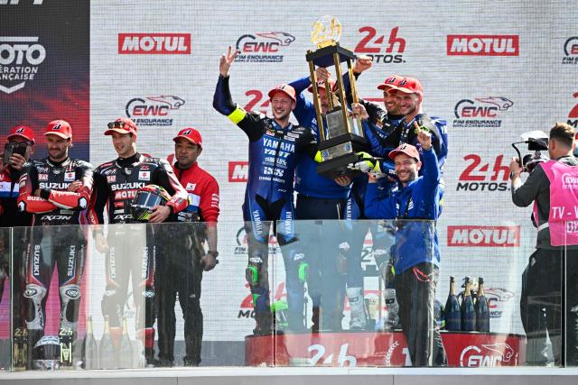 Yart Yamaha Official team's German formula EWC rider Marvin Fritz (L), Yart Yamaha Official team's Argentine formula EWC rider Leandro Mercado (2ndR) and Yart Yamaha Official team's Czech formula EWC rider Karel Hanika (R) hold the trophy in the podium after winning the 49th Le Mans 24-hours endurance moto race, in Le Mans, northwestern France, on April 19, 2026. (Photo by JULIEN DE ROSA / AFP)