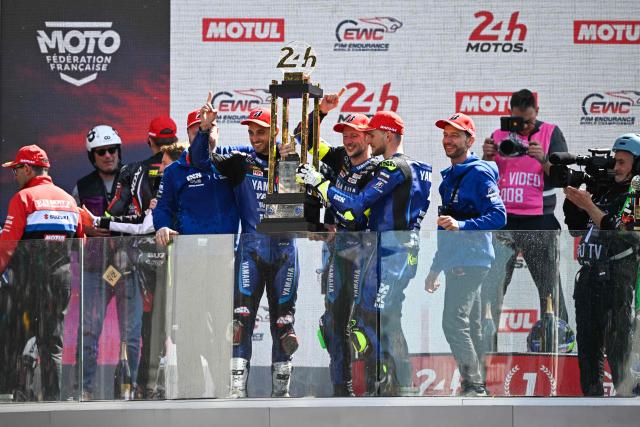 Yart Yamaha Official team's Argentine formula EWC rider Leandro Mercado (C-L), Yart Yamaha Official team's German formula EWC rider Marvin Fritz (C) and Yart Yamaha Official team's Czech formula EWC rider Karel Hanika (C-R) hold the trophy in the podium after winning the 49th Le Mans 24-hours endurance moto race, in Le Mans, northwestern France, on April 19, 2026. (Photo by JULIEN DE ROSA / AFP)
