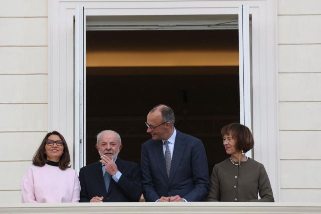 German Chancellor Friedrich Merz (2ndR) and his wife Charlotte Merz (R) pose on the balcony with Brazilian President Luiz Inacio Lula da Silva (2ndL) and Brazilian First Lady Rosangela "Janja" Lula da Silva (L) at their arrival at the Herrenhausen Palace in Hannover, northern Germany, on April 19, 2026, ahead of their visit to the Hannover industrial trade fair. The fair opens its doors to the public on April 20 and will be running until April 24, 2026. (Photo by Odd ANDERSEN / AFP)