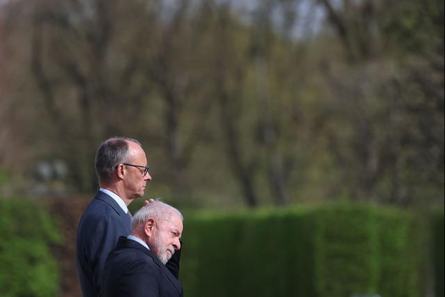 Brazil's President Luiz Inacio Lula Da Silva (R) and Germany's Chancellor Friedrich Merz stand as they review a military guard of honor during a welcoming ceremony at the Herrenhausen Palace in Hannover, Germany on April 19, 2026, ahead of their visit to the Hannover industrial trade fair. The fair opens its doors to the public on April 20 and will be running until April 24, 2026. (Photo by Odd ANDERSEN / AFP)