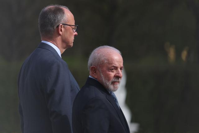 Brazil's President Luiz Inacio Lula Da Silva (R) and Germany's Chancellor Friedrich Merz stand as they review a military guard of honor during a welcoming ceremony at the Herrenhausen Palace in Hannover, Germany on April 19, 2026, ahead of their visit to the Hannover industrial trade fair. The fair opens its doors to the public on April 20 and will be running until April 24, 2026. (Photo by Odd ANDERSEN / AFP)
