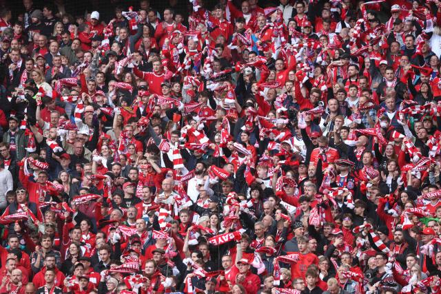 Supporters with red-white scarfs and tricots cheer for FC Bayern Munich prior to the start of the German first division Bundesliga football match between FC Bayern Munich and VfB Stuttgart in Munich, southern Germany, on April 19, 2026. (Photo by Karl-Josef HILDENBRAND / AFP) / DFL REGULATIONS PROHIBIT ANY USE OF PHOTOGRAPHS AS IMAGE SEQUENCES AND/OR QUASI-VIDEO