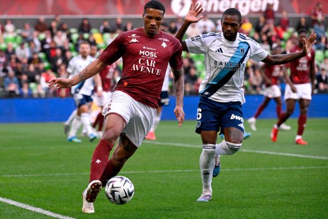 Metz's Ivorian midfielder #05 Jean-Philippe Gbamin (L) fights for the ball with Paris FC's Brazilian defender #06 Otavio (R) during the French L1 football match between FC Metz and Paris FC at the Stade Saint-Symphorien in Longeville-les-Metz, eastern France, on April 19, 2026. (Photo by Jean-Christophe VERHAEGEN / AFP)