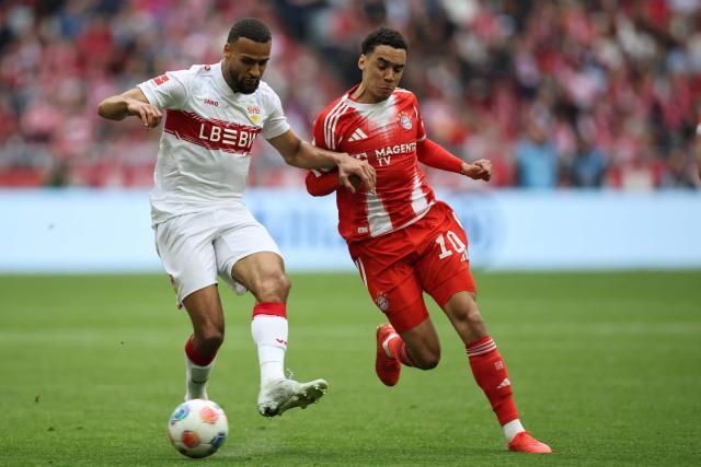 Stuttgart's German defender #04 Josha Vagnoman and Bayern Munich's German midfielder #10 Jamal Musiala vie for the ball during the German first division Bundesliga football match between FC Bayern Munich and VfB Stuttgart in Munich, southern Germany, on April 19, 2026. (Photo by Alexandra BEIER / AFP) / DFL REGULATIONS PROHIBIT ANY USE OF PHOTOGRAPHS AS IMAGE SEQUENCES AND/OR QUASI-VIDEO