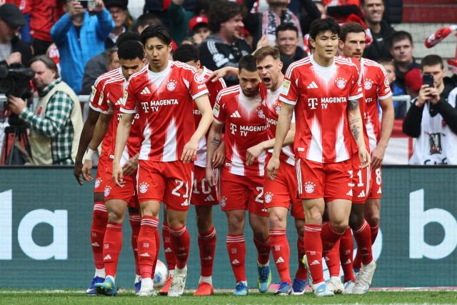 Bayern Munich's Portuguese defender #22 Raphael Guerreiro (C) celebrates scoring the equalising goal 1:1 with his team mates during the German first division Bundesliga football match between FC Bayern Munich and VfB Stuttgart in Munich, southern Germany, on April 19, 2026. (Photo by Alexandra BEIER / AFP) / DFL REGULATIONS PROHIBIT ANY USE OF PHOTOGRAPHS AS IMAGE SEQUENCES AND/OR QUASI-VIDEO