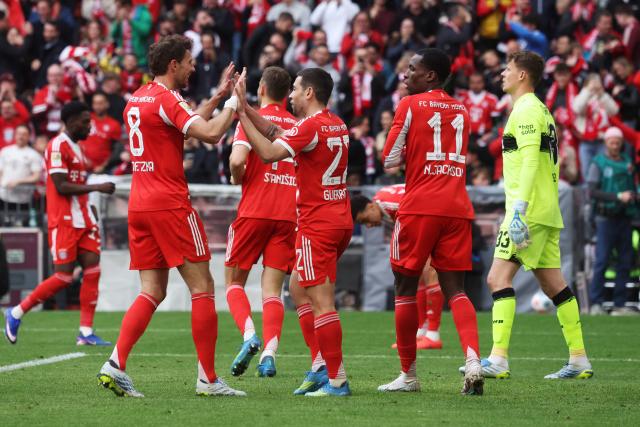 Bayern Munich's Portuguese defender #22 Raphael Guerreiro (C) celebrates with team mates after scoring the equalizing 1-1 goal during the German first division Bundesliga football match between FC Bayern Munich and VfB Stuttgart in Munich, southern Germany, on April 19, 2026. (Photo by Karl-Josef HILDENBRAND / AFP) / DFL REGULATIONS PROHIBIT ANY USE OF PHOTOGRAPHS AS IMAGE SEQUENCES AND/OR QUASI-VIDEO