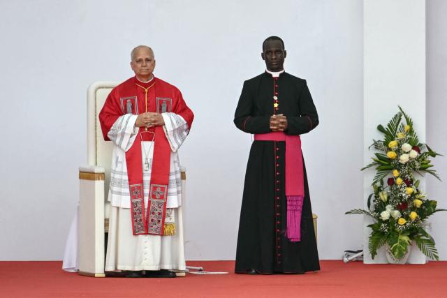 Pope Leo XIV (L) attends a Holy Rosary Prayer on the esplanade in front of the "Mama Muxima" Shrine in Muxima on the seventh day of an 11-day apostolic journey to Africa, on April 19, 2026. (Photo by Alberto PIZZOLI / AFP)