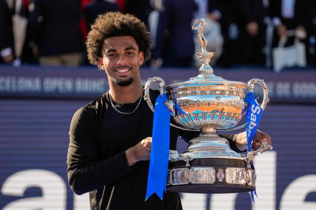 France's Arthur Fils lifts the trophy after winning the men’s singles final against Russia's Andrey Rublev at the ATP Barcelona Open "Conde de Godo" tennis tournament in Barcelona, on April 19, 2026. Fils won 6-2, 7-6 (7/2) (Photo by Manaure Quintero / AFP)