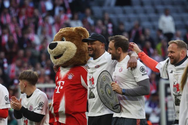 FC Bayern Munich's team and Bayern Munich's Belgian head coach Vincent Kompany (C) celebrate after winning the German first division Bundesliga football match between FC Bayern Munich and VfB Stuttgart as well as the Bundesliga title in Munich, southern Germany, on April 19, 2026. Harry Kane scored his 32nd goal of the campaign as Bayern Munich cruised to a 4-2 home win over Stuttgart and claim a record-extending 35th Bundesliga title. (Photo by Karl-Josef HILDENBRAND / AFP) / DFL REGULATIONS PROHIBIT ANY USE OF PHOTOGRAPHS AS IMAGE SEQUENCES AND/OR QUASI-VIDEO