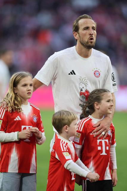 Bayern Munich's English forward #09 Harry Kane and his children celebrates after winning the German first division Bundesliga football match between FC Bayern Munich and VfB Stuttgart in Munich, southern Germany, on April 19, 2026. Harry Kane scored his 32nd goal of the campaign as Bayern Munich cruised to a 4-2 home win over Stuttgart and claim a record-extending 35th Bundesliga title. (Photo by Alexandra BEIER / AFP) / DFL REGULATIONS PROHIBIT ANY USE OF PHOTOGRAPHS AS IMAGE SEQUENCES AND/OR QUASI-VIDEO