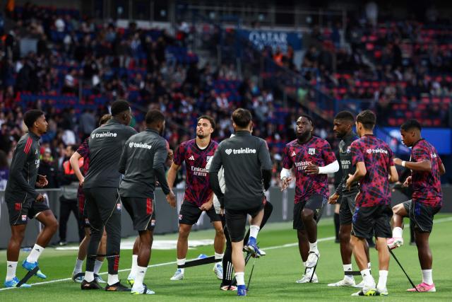 Lyon's Brazilian defender #16 Vinicius Abner, (L)  Lyon's Dutch defender #21 Ruben Kluivert (C), Lyon's Belgian midfielder #05 Orel Mangala (4th R) warm up prior to the French L1 football match between Paris Saint-Germain (PSG) and Olympique Lyonnais (OL) at the Parc des Princes stadium in Paris on April 19, 2026. (Photo by FRANCK FIFE / AFP)