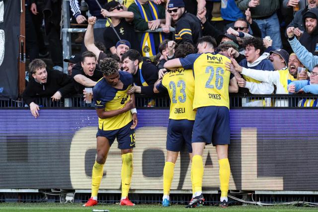 Royale Union Saint-Gilloise's Swedish forward #23 Besfort Zeneli (C) celebrates with teammates and supporters after scoring a goal during the third day of the Champion's Play-offs of the 2025-2026 Belgian championship Pro League first division football match between oyale Union Saint-Gilloise (RUSG) and Club Brugge, in Brussels on April 19, 2026. (Photo by BRUNO FAHY / Belga / AFP) / Belgium OUT