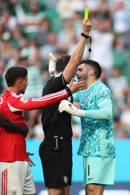 Sporting Lisbon's Portuguese goalkeeper #01 Rui Silva (R) receives a yellow card during the Portuguese League football match between Sporting CP and SL Benfica at Jose Alvalade stadium in Lisbon, on April 19, 2026. (Photo by PATRICIA DE MELO MOREIRA / AFP)