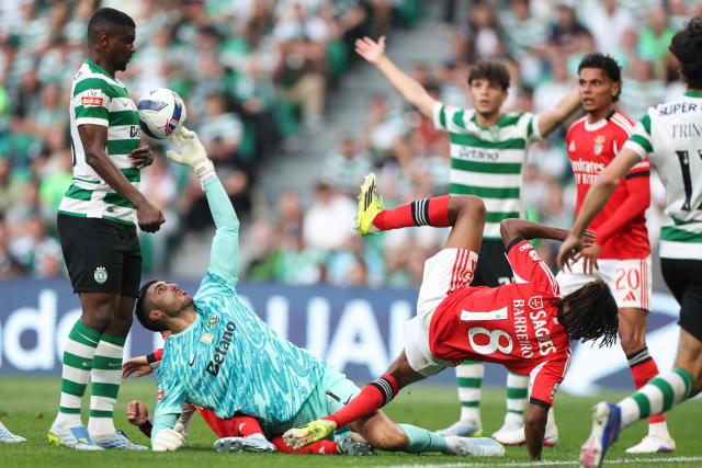 Sporting Lisbon's Portuguese goalkeeper #01 Rui Silva tries to control the ball as SL Benfica's Luxembourgish midfielder #18 Leandro Barreiro (R) falls during the Portuguese League football match between Sporting CP and SL Benfica at Jose Alvalade stadium in Lisbon, on April 19, 2026. (Photo by PATRICIA DE MELO MOREIRA / AFP)