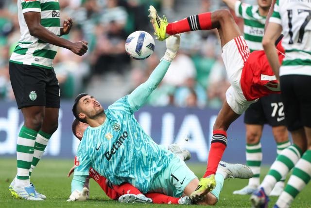 Sporting Lisbon's Portuguese goalkeeper #01 Rui Silva tries to control the ball as SL Benfica's Luxembourgish midfielder #18 Leandro Barreiro (R) falls during the Portuguese League football match between Sporting CP and SL Benfica at Jose Alvalade stadium in Lisbon, on April 19, 2026. (Photo by PATRICIA DE MELO MOREIRA / AFP)