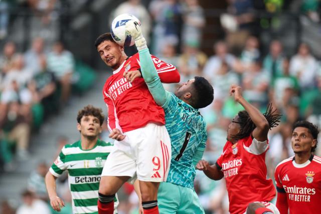 SL Benfica's Croatian forward #09 Franjo Ivanovic heads the ball defended by Sporting Lisbon's Portuguese goalkeeper #01 Rui Silva during the Portuguese League football match between Sporting CP and SL Benfica at Jose Alvalade stadium in Lisbon, on April 19, 2026. (Photo by PATRICIA DE MELO MOREIRA / AFP)