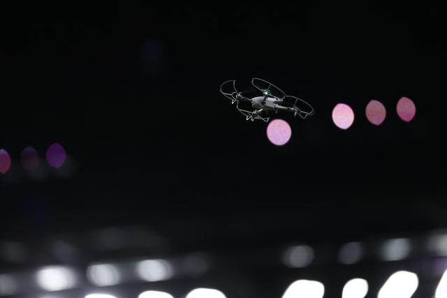A tv broadcast drone flies over the pitch during teams warm up prior to the French Top14 rugby union match between Racing 92 and Stade Francais at the Paris La Defense Arena in Nanterre, on the outskirts of Paris, on April 19, 2026. (Photo by Kenzo TRIBOUILLARD / AFP)