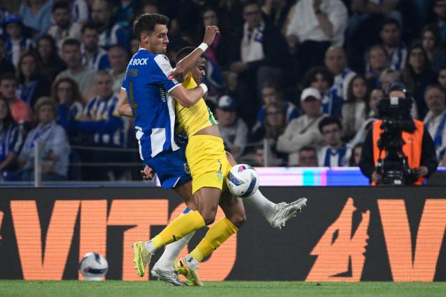 FC Porto's Polish defender #04 Jakub Kiwior (L) challenges Tondela's Brazilian forward #07 Pedro Pereira dos Santos during the Portuguese League football match between FC Porto and CD Tondela at Dragao stadium in Porto on April 19, 2026. (Photo by Miguel RIOPA / AFP)