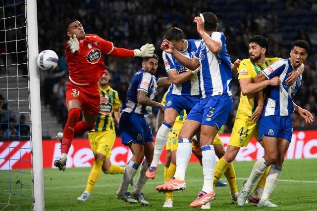 FC Porto's Polish defender #05 Jan Bednarek (C) fails to score with a header past Tondela's Brazilian goalkeeper #31 Bernardo Fontes during the Portuguese League football match between FC Porto and CD Tondela at Dragao stadium in Porto on April 19, 2026. (Photo by Miguel RIOPA / AFP)
