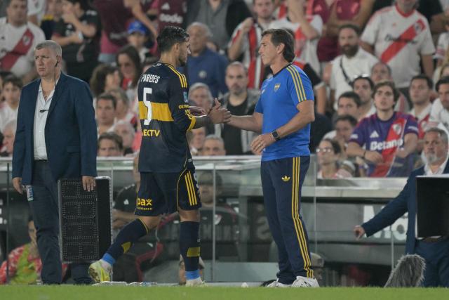Boca Juniors' midfielder #05 Leandro Paredes shakes hands with head coach Claudio Ubeda as he leaves the pitch after being substituted off during the Argentine Professional Football League 2026 Apertura Tournament match between River Plate and Boca Juniors at MAS Monumental stadium in Buenos Aires on April 19, 2026. (Photo by JUAN MABROMATA / AFP)