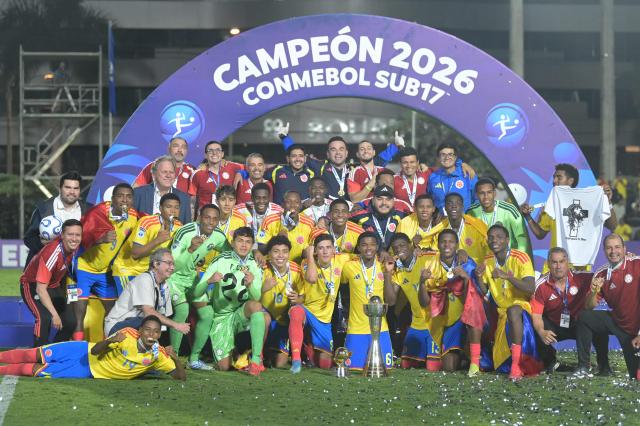 Colombia’s players pose for a photo with the trophy after winning the South American U-17 Championship final football match between Argentina and Colombia at the CARFEM Stadium in Ypane, Paraguay, on April 19, 2026. (Photo by Daniel DUARTE / AFP)