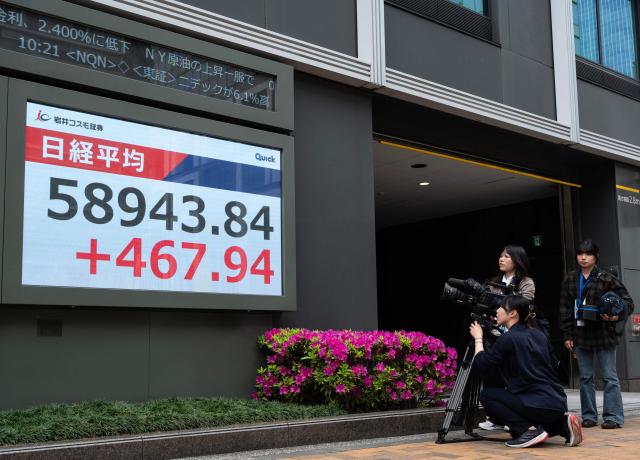 A camera crew films a display of the Nikkei Stock Average near the Tokyo Stock Exchange in Tokyo on April 20, 2026. (Photo by Andrew CABALLERO-REYNOLDS / AFP)