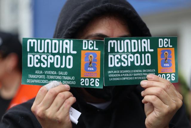 A demonstrator shows flyers during a protest against the Gran Tenochtitlan bike path and the organisation of the World Cup in Mexico City on April 19, 2026. The Gran Tenochtitlan is an infrastructure project designed to connect Banorte Stadium (formerly Azteca Stadium) with other points of interest in Mexico City, according to the local government. (Photo by Luis CORTES / AFP)