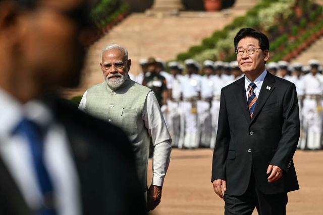 India's Prime Minister Narendra Modi (L) walks with South Korea's President Lee Jae Myung (R) during a ceremonial reception at India's presidential palace Rashtrapati Bhavan in New Delhi on April 20, 2026. (Photo by Sajjad HUSSAIN / AFP)