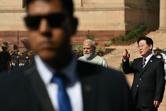 India's Prime Minister Narendra Modi (C) walks with South Korea's President Lee Jae Myung (R) during a ceremonial reception at India's presidential palace Rashtrapati Bhavan in New Delhi on April 20, 2026. (Photo by Sajjad HUSSAIN / AFP)