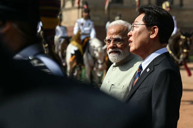India's Prime Minister Narendra Modi (C) walks with South Korea's President Lee Jae Myung (R) during a ceremonial reception at India's presidential palace Rashtrapati Bhavan in New Delhi on April 20, 2026. (Photo by Sajjad HUSSAIN / AFP)