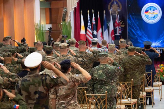 Philippine and US soldiers salute as their national anthems are played during the opening ceremony of the annual Balikatan (shoulder to shoulder) joint military exercise at Camp Aguinaldo in Quezon city, suburban Manila on April 20, 2026. Thousands of American and Philippine troops, joined for the first time by a significant contingent of Japanese forces, began annual military exercises on April 20 set against the backdrop of the Middle East war. (Photo by Ted ALJIBE / AFP)