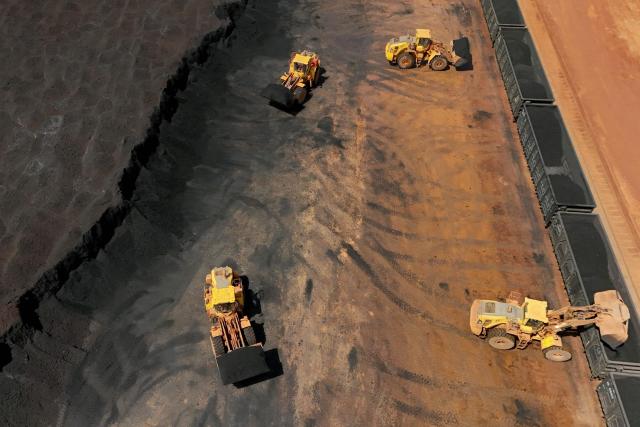 Excavators load imported coal onto a train in Yantai, in China's eastern Shandong province on April 20, 2026. (Photo by CN-STR / AFP) / China OUT