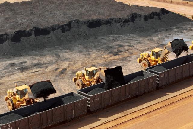 Excavators load imported coal onto a train in Yantai, in China's eastern Shandong province on April 20, 2026. (Photo by CN-STR / AFP) / China OUT