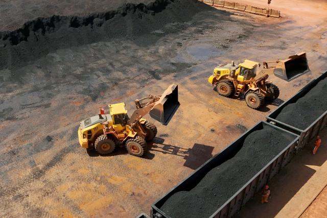 Excavators load imported coal onto a train in Yantai, in China's eastern Shandong province on April 20, 2026. (Photo by CN-STR / AFP) / China OUT